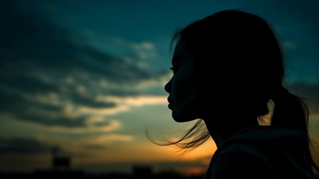 Silhouette of a girl on the sunset background. Selective focus.の素材