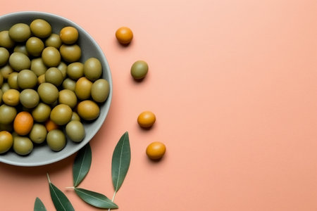 green olives in a bowl on a pink background with copy spaceの素材