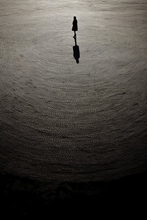 Silhouette of a woman standing in the water with reflection.の素材