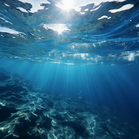 Underwater view of blue sea with sunbeams coming out of waterの素材