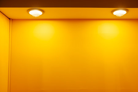 Yellow wall with a light bulb in the corner. Abstract background.の素材
