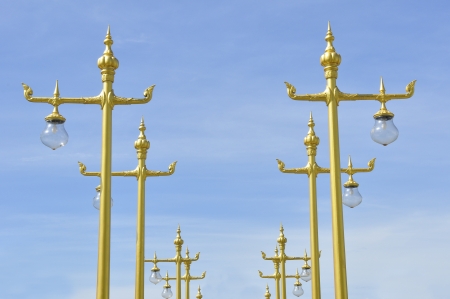 Pathway of golden Thai street lamp with blue skyの写真素材