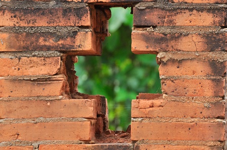orange brick wall with hole crossの写真素材