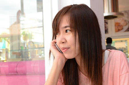 Girl speaking telephone and looking out of the window のeditorial素材