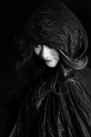 Mysterious portrait of young beautiful woman in the black dressの写真素材