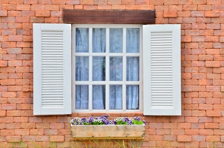 Beautiful white wooden window on old brick wallの写真素材