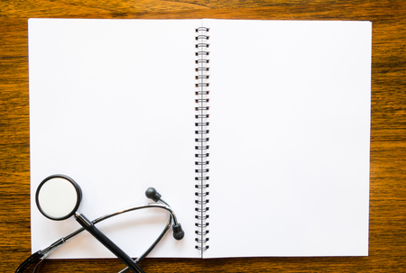 Stethoscope with open blank book on grungy wood backgroundの写真素材