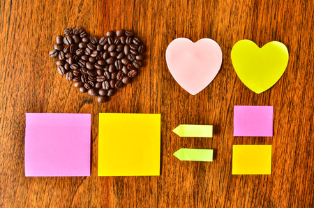 Coffee bean with heart shape and colorful stick note on wood backgroundの写真素材