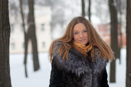 portrait of young woman in winter park with long hairの写真素材