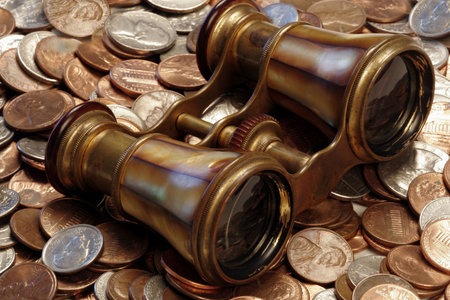 An old brass set of opera glasses atop US coins portrays the search for financial clarity