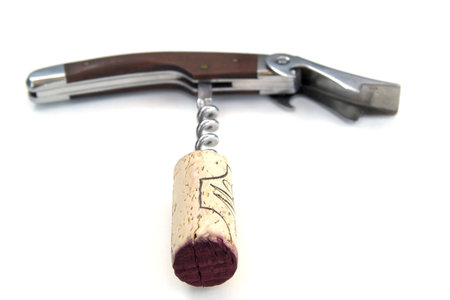 Corkscrew with wooden handle, red wine soaked cork attached