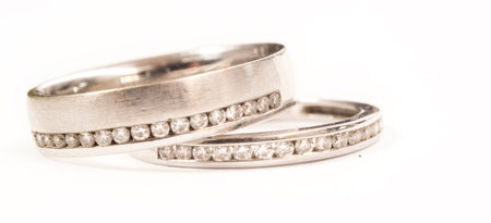 Macro picture of delicate white gold wedding rings with real diamonds. Selective focus on the...