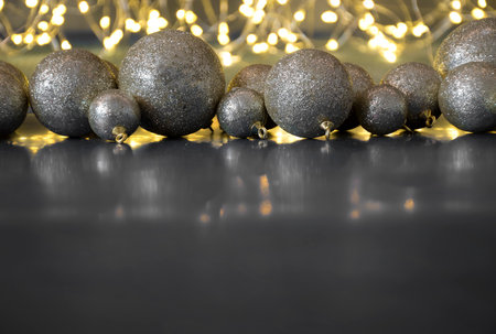 Christmas baubles on dark. Copy space with a minimalistic design. Shiny lights with bokeh effect. Selective focus on the shimmery balls, blurred.の写真素材