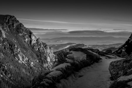 High contrast monochrome Tatra Mountain view, Poland. The rocks illuminated by the sunlight, shadowy areas make dramatic effect. Selective focus on the crags, blurred background.の写真素材