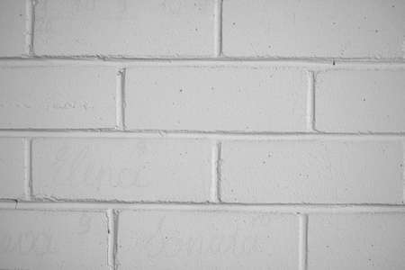 White brick wall texture. Symmetrical geometric shape. Straight lines, block construction, rough surface. Selective focus on the details, blurred background.の写真素材