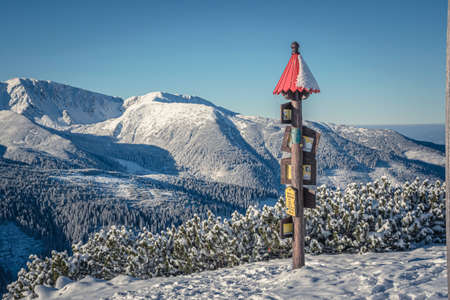 Tatra Mountains, Slovakia - December 1st 2020: Slovak mountain sign on top of LÃºÄna Peak. Wooden signpost with the name of the summit, height and directions for hikers. Selective focus on structure.のeditorial素材