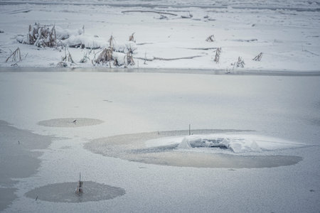 Frozen water closeup in a river. Rough ice texture, tiny crystal shapes, cold winter morning in...