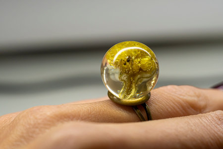 Dwarf everlast ring on a finger. Sphere ball made of epoxy resin with natural dried flowers inside....