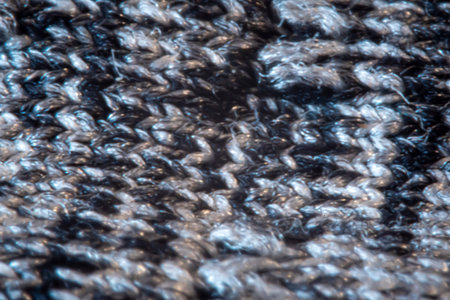Blurry creative knitted pattern. Grey and black threads closeup, textured material, blurred fabric...