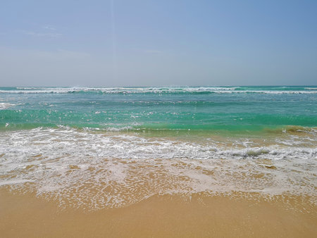 Clear blue ocean water in Africa. White foam on the waves, turquoise transparent surface, sunny day. Selective focus on the details, blurred background.の写真素材
