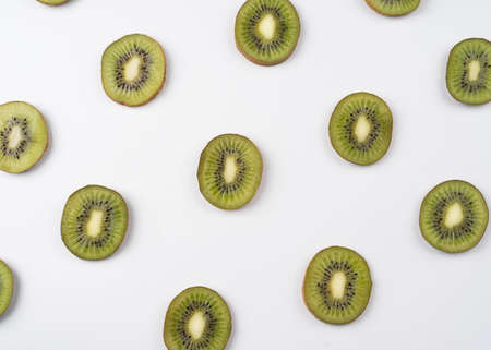 Kiwi fruit sliced macro. Ripe kiwi fruit isolated on white background. flat lay image of kiwi. Fresh tropical fruit abstract background. Pattern of kiwi fruitの写真素材