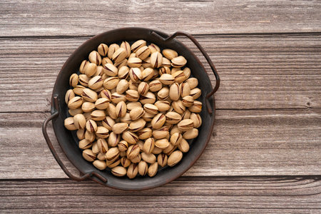 pistachio in shell nuts in a tray on wooden table background with copy space