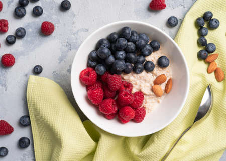 oatmeal in a plate with raspberries and blueberries and almondsの写真素材