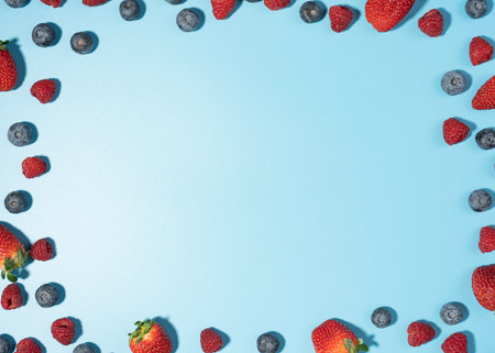 Bunch of fresh organic strawberry berries in seamless circle pattern, blue background. Clean and healthy eating concept. Healthy vegan raw diet snack. Close up, copy space, top view with copy spaceの写真素材