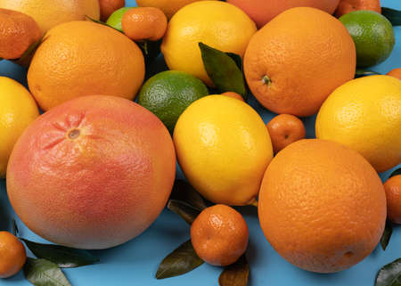 Macro photo with citrus fruit with visible texture in high resolution, fresh oranges, grapefruit, lemons, tangerines with leaves, top view healthy foodの写真素材