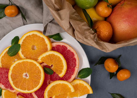 Various citrus fruits border with green leaves on white background. Top view. Halves of citrus. Vitamin Cの写真素材
