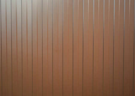 Corrugated sheet vertical metal texture background. The texture of the metal fence from the profile brown sheet with vertical linesの写真素材