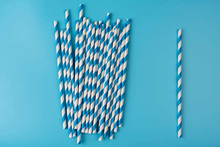 Blue and white drinking straws for beverage on a bright background. one straw and many straws concept. ecological variationの写真素材