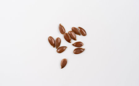 Flax seeds isolated on white background. Top view. Macro shoot of dry flax. flax seed spread out on...
