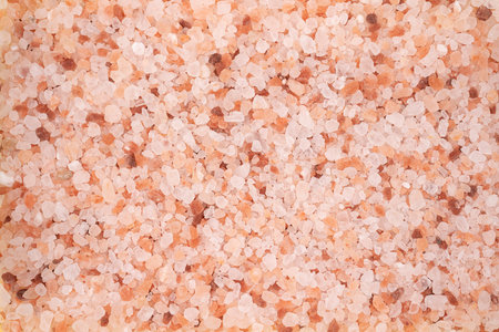 Pink himalayan salt background. Close up. Himalayan salt scattered on a table. pink salt cristalize...