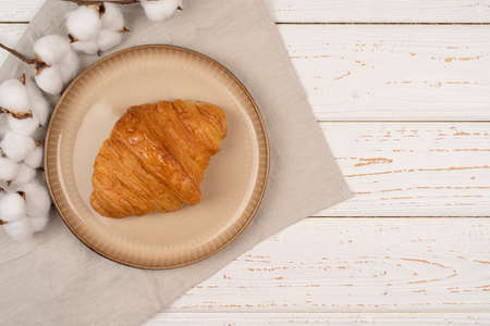 Fresh growing with honey, white wooden table background, served table for the breakfast. tasty croissant on a plate with copy spaceの写真素材