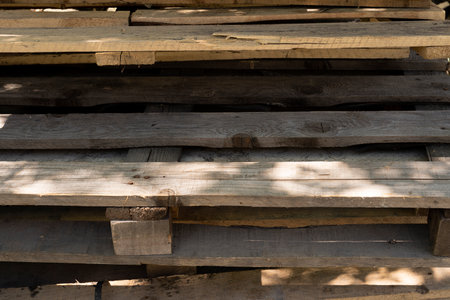 old wooden pallets. garbage removal. old wooden pallets for recycling. Many pallets stacked in stock, warehouse pallets, old wooden palletsの写真素材