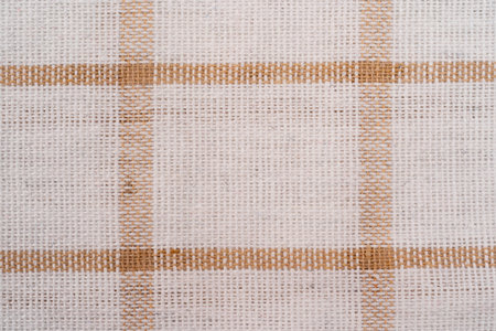 Beige checkered fabric with white colored threads. Fabric for plaid coat and suit. Close-up....