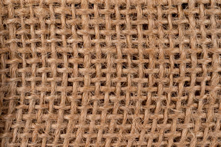 Rural texture of sackcloth. Background of very coarse, rough fabric woven made of flax, jute or hemp. Burlap bag material. Design element. Sacking and bagging pattern. Top view. Macro imageの写真素材
