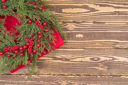Christmas wreath with red winter berries on a wooden table, useful as Christmas background. with copy space for textの写真素材