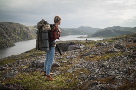 Woman Traveler with Backpack hiking in Mountains.の写真素材