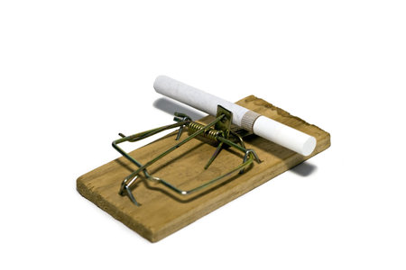 Cigarettes and mousetrap isolated on white background.