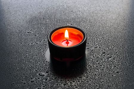 Red candles in the dark background of water drops.の写真素材