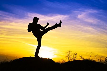 Man in the sunset and the karate kick.の写真素材