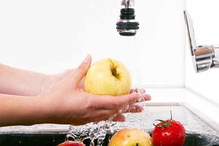 Women wash the apples in the kitchen.の写真素材