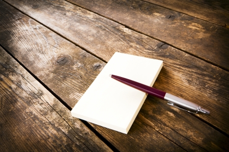 Notebook and pen on the wooden table の写真素材
