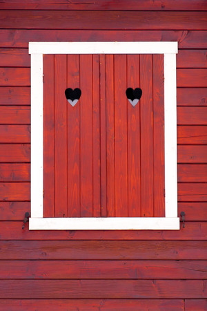 Stained wood window shutters closed, her heart symbol の写真素材