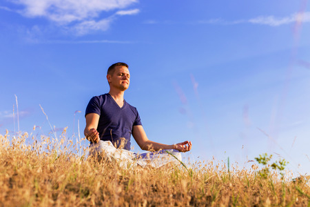 The peaceful scenery of a man meditating in the lotus position.の写真素材