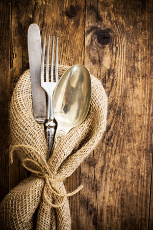 The old wooden table cutlery on the burlap.の写真素材