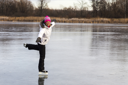 Girl on the lake ice, skate merrily.の写真素材