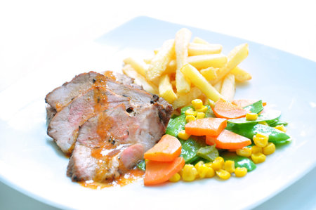 Roasted beef with gravy sauce and fried potatoesの写真素材